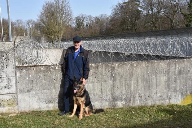 Jürg Berger mit Schäferhund Dusty vor den Gittern der Justizvollzugsanstalt Pöschwies in Regensdorf.